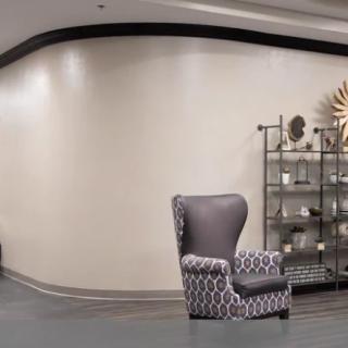 A modern lobby featuring a patterned armchair and decorative shelving.