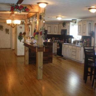 A spacious kitchen with an open-plan design, featuring wood flooring and elegant cabinetry.