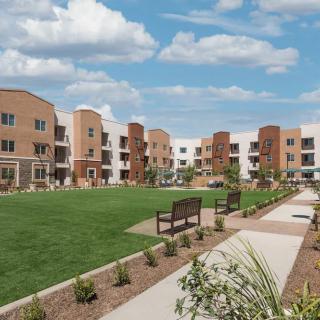 Modern apartment complex with landscaped grounds and pathways.