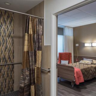 A cozy hospital room interior with a bed and privacy curtain.