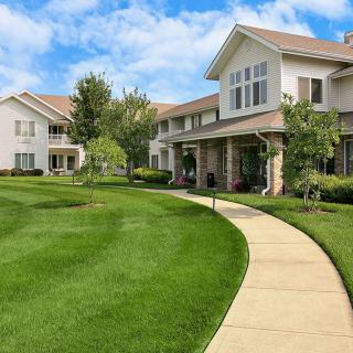 A well-maintained residential complex with lush green landscaping and a winding pathway.