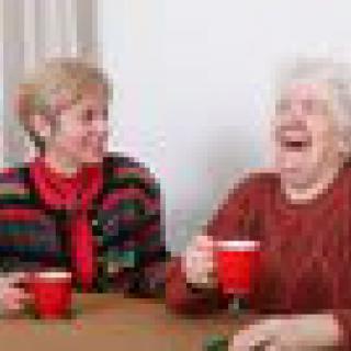Two seniors enjoying a laugh over coffee.