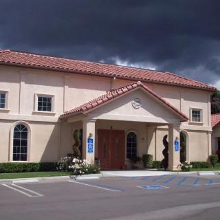 A church building with a tile roof under a cloudy sky.