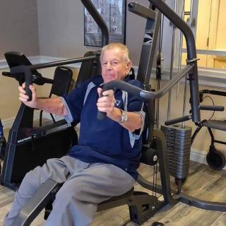 A senior person using gym equipment for strength training.