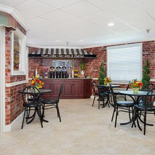 A cozy indoor cafe with brick walls, featuring tables, chairs, and a counter.