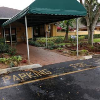 Covered building entrance with designated parking area.