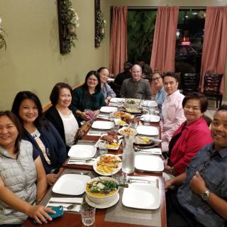 A group of friends gathered around a table for dinner at a restaurant.
