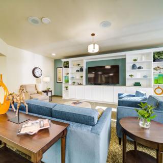 A modern living room with a comfortable sofa, large television, and stylish bookshelves.