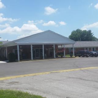 A commercial building with a triangular roof under a clear blue sky.