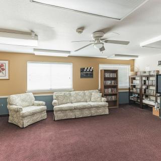 A comfortable living room with sofas, a bookshelf, and a TV.