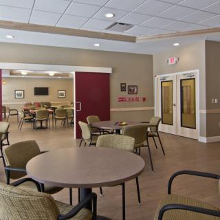 An empty meeting room with several tables and chairs arranged neatly.