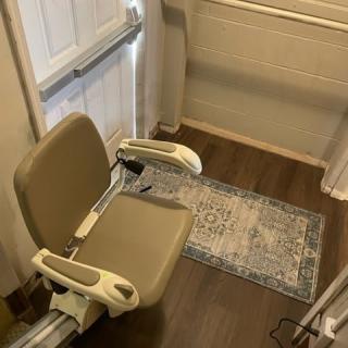 A stairlift chair installed indoors to assist with mobility.
