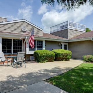 A cozy suburban house with a patio, outdoor seating, and an American flag displayed.