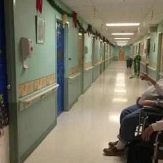 A decorated hallway in a nursing home, with residents sitting in wheelchairs.