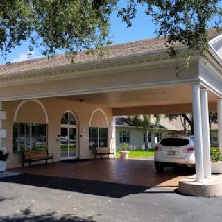 A welcoming entrance to a residential building with a car parked under the portico.