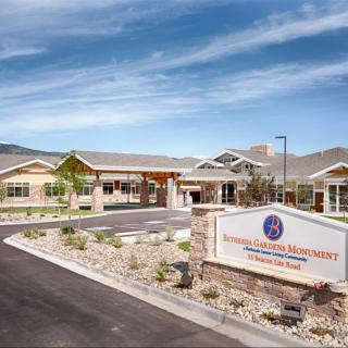 Modern building entrance with landscaped surroundings and clear signage.