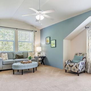 A cozy living room featuring a sofa, armchair, and coffee table against a blue accent wall.