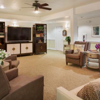 A cozy living room with comfortable seating, a large television, and elegant decor.