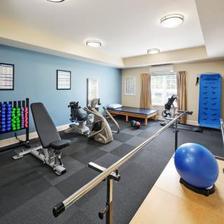 A well-equipped fitness room with various exercise machines and weights.