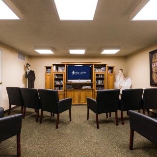 A cozy waiting room with rows of chairs facing a television.