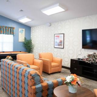 A cozy, modern living room with orange furniture and a large TV.