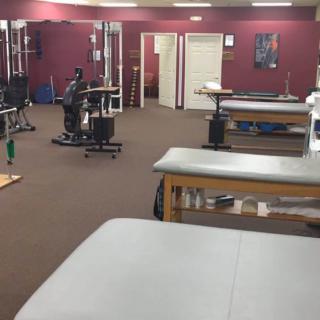 A physical therapy clinic with treatment tables and exercise equipment.