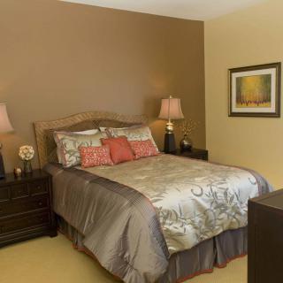 A cozy bedroom with warm-toned walls and elegant decor.