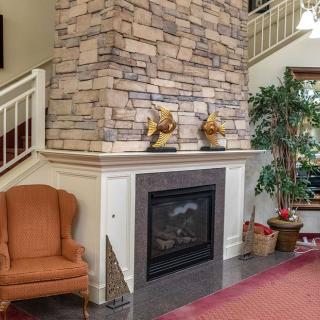 A cozy living room featuring a stone fireplace and comfortable seating.