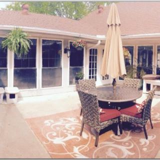 A cozy patio setting with wicker chairs, a table, and an umbrella.