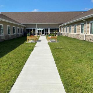 A courtyard with a concrete pathway leading to a building entrance.