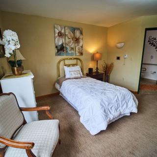 A cozy bedroom with a single bed, elegant decor, and soft lighting.