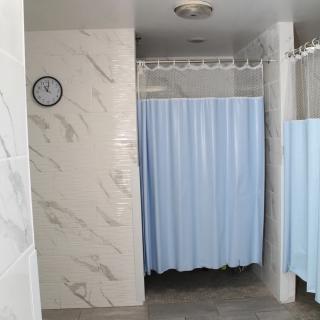 A bathroom with tiled walls and blue shower curtains.