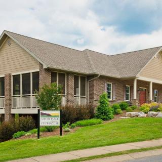 A suburban house with a brick exterior and landscaped front yard.