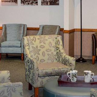 A cozy waiting area featuring patterned chairs and a table with coffee mugs.