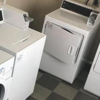 A row of laundry appliances in a laundromat.