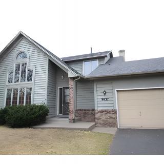 A two-story suburban house with an attached garage and front yard.