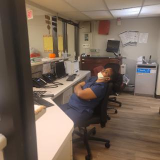 An individual resting at their desk in an office setting.