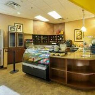 A cozy cafe interior featuring a dessert display case and coffee station.