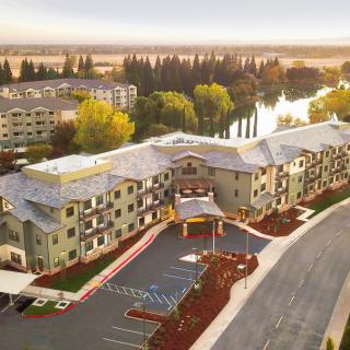 Aerial view of a residential building complex near a river during sunset.