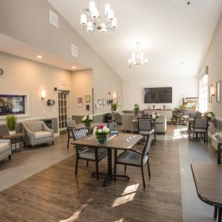 A spacious and modern dining room interior with ample seating and elegant chandeliers.