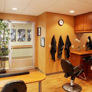 A neatly designed interior of a hair salon featuring a barber chair, waiting area, and stylish decor.