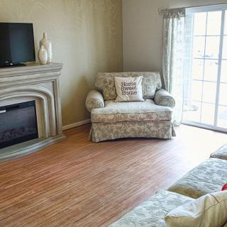 A cozy living room with a fireplace, armchair, and sliding door.