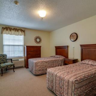 A cozy bedroom with two twin beds and classic wooden furniture.
