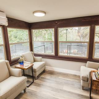 A cozy living room with large windows offering natural light and a modern design.