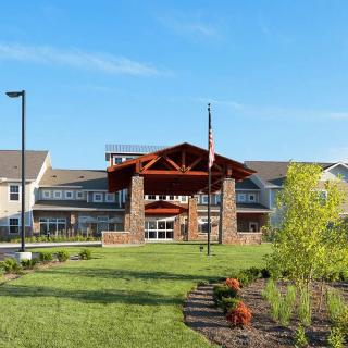 A modern building with a landscaped entrance on a clear day.