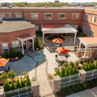 A serene outdoor courtyard featuring vibrant gardens and comfortable seating areas.