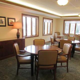 A well-lit dining area with multiple tables and chairs arranged for seating.