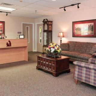 A cozy waiting room with a sofa, reception desk, and decorative elements.