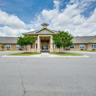 A symmetrical building with a prominent entrance under a partly cloudy sky.