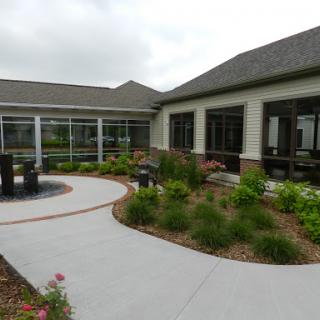 A serene outdoor space featuring a landscaped garden, curved pathway, and modern architectural design.